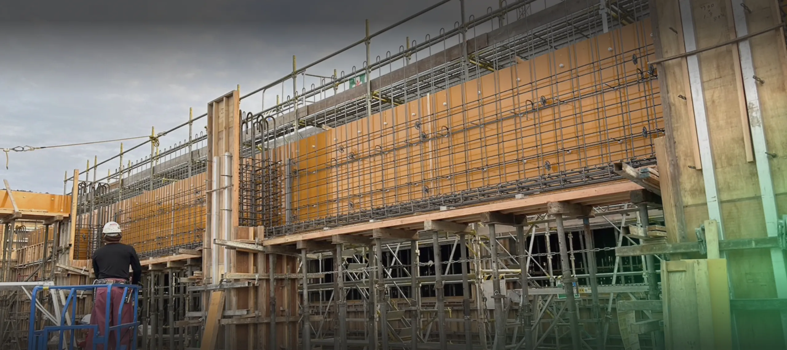 足場の上で鉄筋を使った作業をしている風景